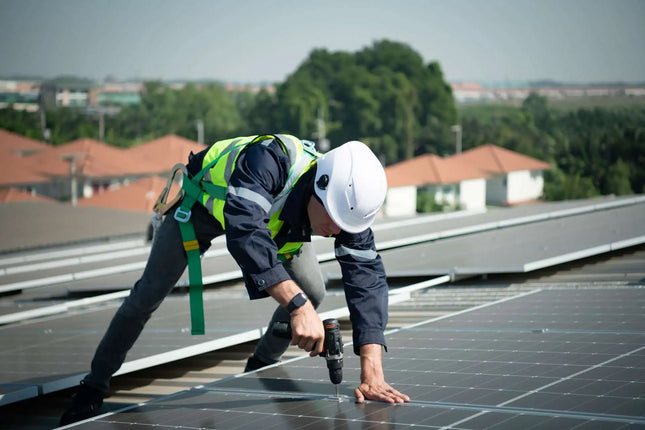 technicien qui installe un kit solaire photovoltaique sur le toit d'une maison. installation en autoconsommation 